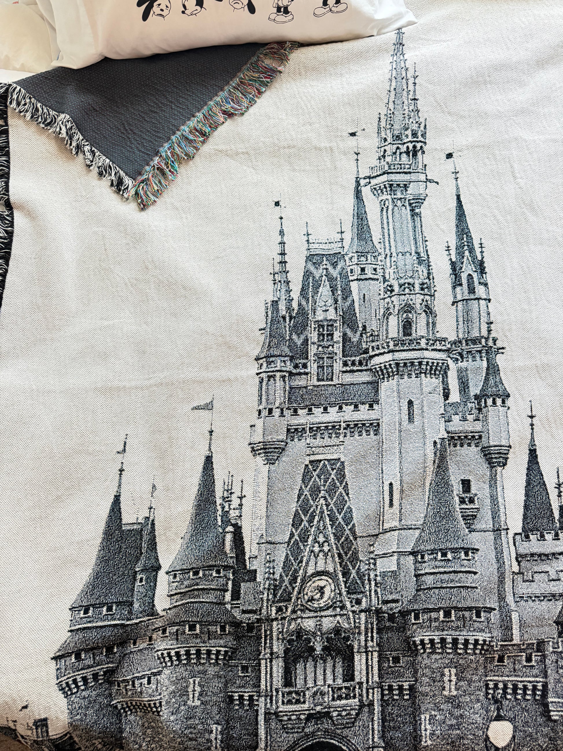 Woven Orlando castle throw blanket draped across bed.