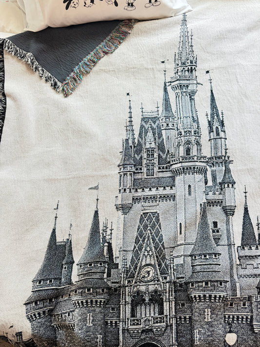 Woven Orlando castle throw blanket draped across bed.
